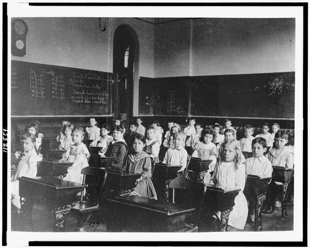 Students seated in rows of desks in a Washington, D.C., classroom, circa 1899.